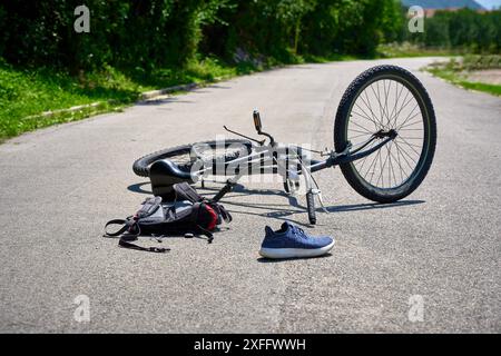 Torbole, Gardasee, Italien - 30. Juni 2024: Symbolisches Bild eines Verkehrsunfalls mit einem Fahrrad. Fahrradunfall mit Fahrrad auf der Straße und vom Radfahrer verstreuten Objekten *** Symbolbild Verkehrsunfall mit einem Fahrrad. Fahrradunfall mit Rad auf der Straße und verstreuten Gegenstände von dem Radfahrer gestellte Szene Stockfoto