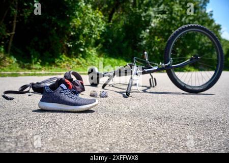 Torbole, Gardasee, Italien - 30. Juni 2024: Symbolisches Bild eines Verkehrsunfalls mit einem Fahrrad. Fahrradunfall mit Fahrrad auf der Straße und vom Radfahrer verstreuten Objekten *** Symbolbild Verkehrsunfall mit einem Fahrrad. Fahrradunfall mit Rad auf der Straße und verstreuten Gegenstände von dem Radfahrer gestellte Szene Stockfoto