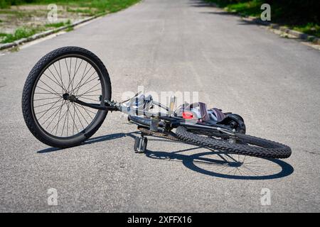 Torbole, Gardasee, Italien - 30. Juni 2024: Symbolisches Bild eines Verkehrsunfalls mit einem Fahrrad. Fahrradunfall mit Fahrrad auf der Straße und vom Radfahrer verstreute Objekte posierte Szene Luftbild *** Symbolbild Verkehrsunfall mit einem Fahrrad. Fahrradunfall mit Rad auf der Straße und verstreuten Gegenstände von dem Radfahrer stellte Szene Luftaufnahme Stockfoto