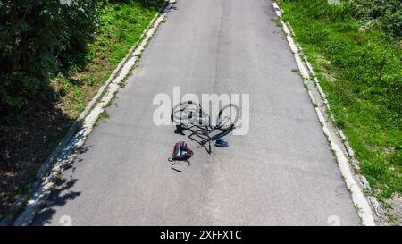 Torbole, Gardasee, Italien - 30. Juni 2024: Symbolisches Bild eines Verkehrsunfalls mit einem Fahrrad. Fahrradunfall mit Fahrrad auf der Straße und vom Radfahrer verstreute Objekte posierte Szene Luftbild *** Symbolbild Verkehrsunfall mit einem Fahrrad. Fahrradunfall mit Rad auf der Straße und verstreuten Gegenstände von dem Radfahrer stellte Szene Luftaufnahme Stockfoto