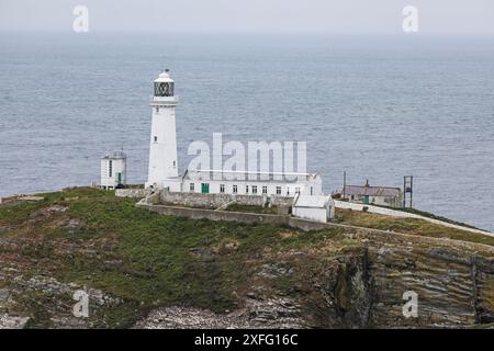 Ein Blick auf den Leuchtturm von South Stack und die spektakuläre Lage auf einem Felsvorsprung nordwestlich von Holyhead, Anglesey, Nordwales Stockfoto