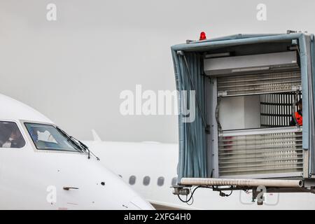 03. Juli 2024, Nordrhein-Westfalen, Düsseldorf: Der Finger, an dem Passagiere nach Landung eines Flugzeugs aussteigen, wird auf ein Flugzeug manövriert. Foto: Christoph Reichwein/dpa Stockfoto