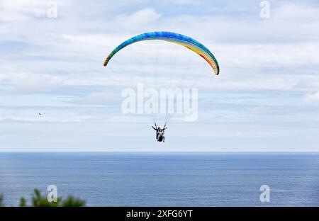 Extremsport. Paragliding, geboren im 20. Jahrhundert, aufgrund des Erfindungsreichtums der Bergsteiger, die nach unten fliegen wollten. Gijón, Asturien, Spanien. Stockfoto