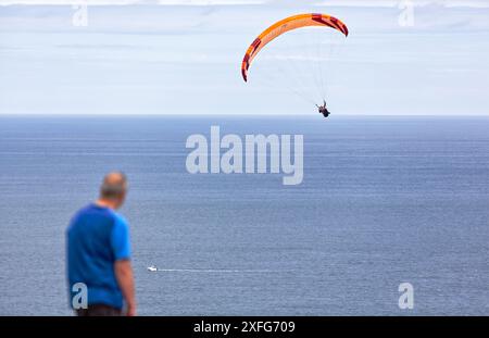 Extremsport. Paragliding, geboren im 20. Jahrhundert, aufgrund des Erfindungsreichtums der Bergsteiger, die nach unten fliegen wollten. Gijón, Asturien, Spanien. Stockfoto