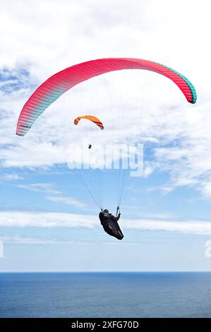 Extremsport. Paragliding, geboren im 20. Jahrhundert, aufgrund des Erfindungsreichtums der Bergsteiger, die nach unten fliegen wollten. Gijón, Asturien, Spanien. Stockfoto