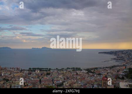 Gelber Sonnenuntergang über der Bucht und dem Meer in Italien, Blick von oben. Bucht von Neapel am Abend während Sonnenuntergang, Panoramablick, italienische Touristenspaziergänge herum Stockfoto