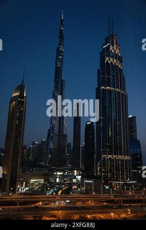 Die Skyline der nahegelegenen Türme erzeugt eine Silhouette, wenn die Dunkelheit fällt. Am höchsten sind die bleistiftdünnen Stahlkonstruktionen der 828 Meter (2.716,5 ft) Bur Stockfoto