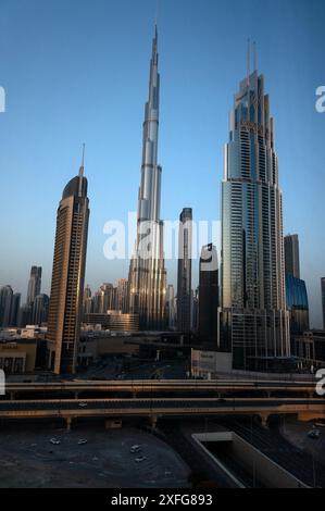 Eine Skyline aus nahe gelegenen Türmen erzeugt eine Silhouette, wenn die Sonne bei Sonnenaufgang aufgeht und ihre Höhepunkte auf die höchste Stahlkonstruktion mit Bleistiftdünn 828 m wirft Stockfoto