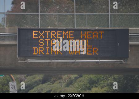 Ein Schild mit extremer Hitze, kühl bleiben, Wasser trinken auf einer Tafel am Interstate 105 Freeway, 2. Juli 2024, in Los Angeles. Stockfoto