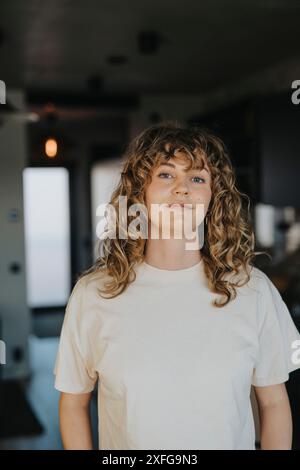Porträt einer Frau mit lockigem Haar, die zu Hause steht Stockfoto