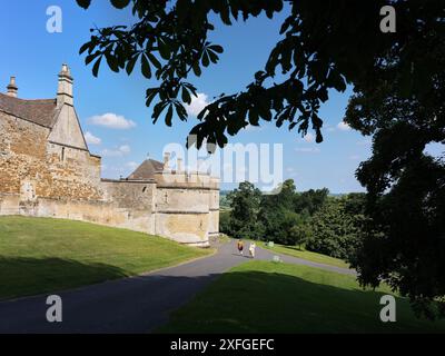 Ein paar Besucher neben den runden Doppeltürmen in Rockingham Castle, Corby, England, einer ehemaligen königlichen Burg, die von König Wilhelm I., dem Eroberer, erbaut wurde. Stockfoto