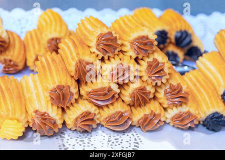 Ein Stapel Brownies mit Schokoladenfrosting darauf. Die Zuckerguss ist dick und cremig, und die Brownies sind goldbraun. Der Stapel ist hoch gestapelt, Creati Stockfoto