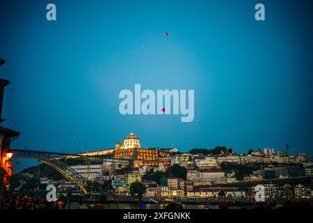 Bunte Ballons erfüllen während São João den Himmel über dem historischen Viertel von Porto und verleihen der beliebten jährlichen Feier der Stadt einen festlichen Touch. Stockfoto