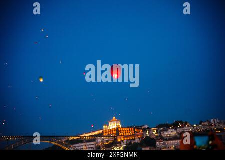 Bunte Ballons erfüllen während São João den Himmel über dem historischen Viertel von Porto und verleihen der beliebten jährlichen Feier der Stadt einen festlichen Touch. Stockfoto