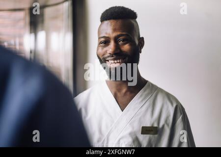 Lächelnder bärtiger männlicher Gesundheitsarbeiter im Krankenhaus Stockfoto