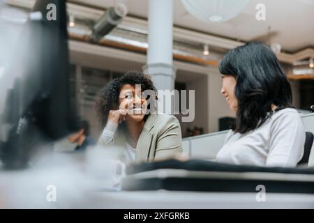 Niederwinkelansicht von Unternehmerinnen, die im Amt diskutieren Stockfoto