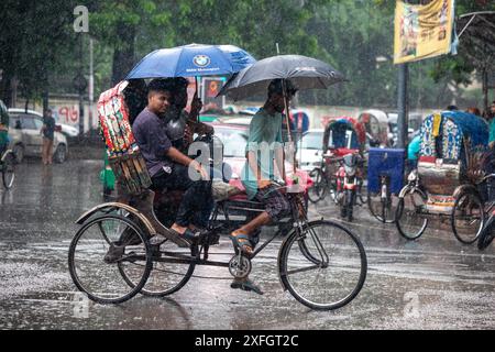 Dhaka, Bangladesch. Juli 2024. Am Mittwoch, den 03. Juli 2024, benutzen die Menschen Regenschirme, um vor Regen in Dhaka, Bangladesch, zu schützen. (Kreditbild: © Md. Rakibul Hasan/ZUMA Press Wire) NUR REDAKTIONELLE VERWENDUNG! Nicht für kommerzielle ZWECKE! Stockfoto