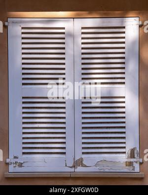 Fenster mit weißen Holzläden und weißen Holzjalousien Stockfoto
