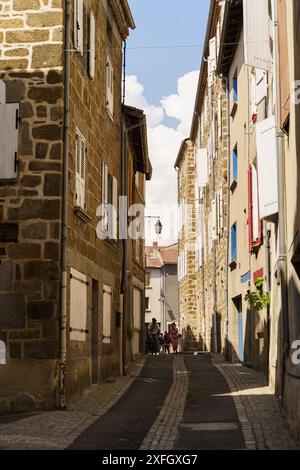 Langeac, Frankreich - 28. Mai 2023: Eine enge, kopfsteingepflasterte Gasse in der charmanten Stadt Langeac, Frankreich, in warmes Sonnenlicht getaucht. Stockfoto