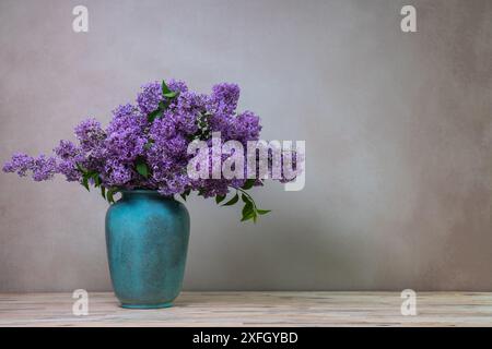 Ein riesiger Fliederstrauß in einer großen Vase, isoliert auf einem hellgrauen Hintergrund. Stillleben mit Blumen, viel Platz für Text Stockfoto