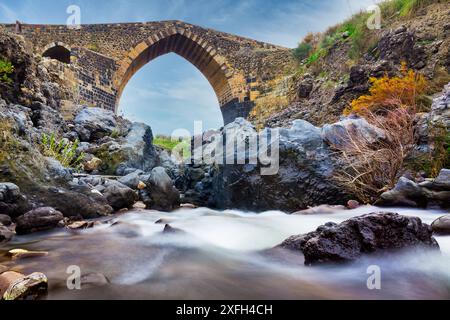 Ponte dei Saraceni (Sarazenbrücke). Eine antike mittelalterliche Brücke aus der normannischen Zeit am Simeto-Fluss. Catania, Sizilien, Italien. Bild Langzeitbelichtung Stockfoto