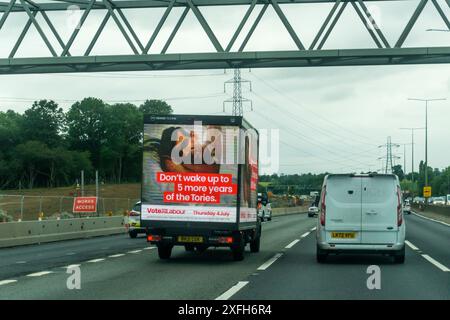 3. Juli 2024. Am letzten Tag vor der Wahl der britischen Parlamentswahlen wird ein Werbewagen der Labour Party auf der M25 in Essex mit der Botschaft „Wecken Sie nicht mehr bis zu fünf Jahre der Tories“ und einem Bild von Rishi Sunak im Bett gesehen. Stockfoto