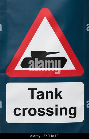 Ein rot-weißes dreieckiges Warnschild mit „Tank Crossing“ (Tanküberquerung) Stockfoto