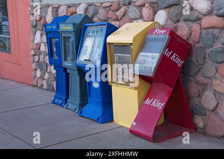 Reihe von Zeitungskisten auf dem Bürgersteig in der Innenstadt von Cottonwood Arizona – April 2024 Stockfoto