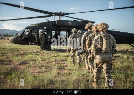 Ivy Soldaten, die dem 2. Bataillon, 23. Infanterieregiment, 1. Stryker Brigade Combat Team, 4. Infanteriedivision, zusammen mit Soldaten der 10. Special Forces Group, gehen zu einem UH-60 Blackhawk Hubschrauber aus dem 3. Angriffshubschrauber Bataillon, 4. Kampfluftbrigade, 4. Infanteriedivision, 4. während eines Luftangriffs zur Durchführung spezieller Aufklärungsoperationen in Verbindung mit IVY MASS in Fort Carson, Colorado, am 6. Juni 2024. (Foto der US-Armee von SPC. Joshua Zayas) Stockfoto