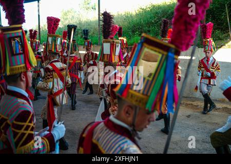 Das Festival „Bugiada e Mouriscada“ in São João de Sobrado, Valongo, Portugal, erwacht am 24. Juni zum Leben. Die Mourisqueiros tragen bunte Kostüme und führen historische Schlachten gegen die Bugios in einer lebhaften Feier der Tradition und Geschichte nach. Stockfoto