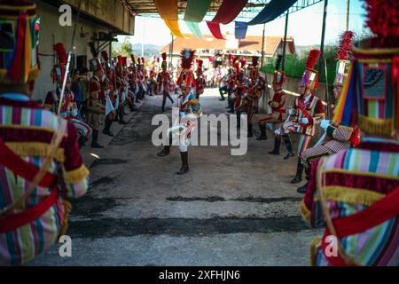 Das Festival „Bugiada e Mouriscada“ in São João de Sobrado, Valongo, Portugal, erwacht am 24. Juni zum Leben. Die Mourisqueiros tragen bunte Kostüme und führen historische Schlachten gegen die Bugios in einer lebhaften Feier der Tradition und Geschichte nach. Stockfoto