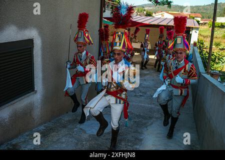 Das Festival „Bugiada e Mouriscada“ in São João de Sobrado, Valongo, Portugal, erwacht am 24. Juni zum Leben. Die Mourisqueiros tragen bunte Kostüme und führen historische Schlachten gegen die Bugios in einer lebhaften Feier der Tradition und Geschichte nach. Stockfoto