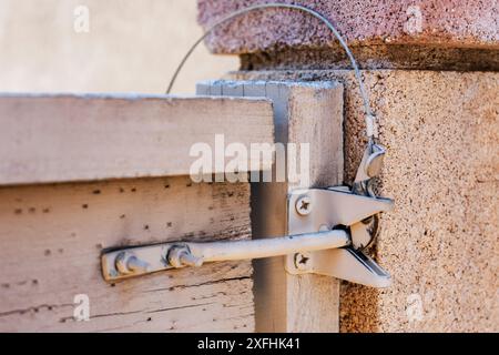 Nahaufnahme einer hölzernen Torverriegelung mit äußerer Entriegelung Stockfoto