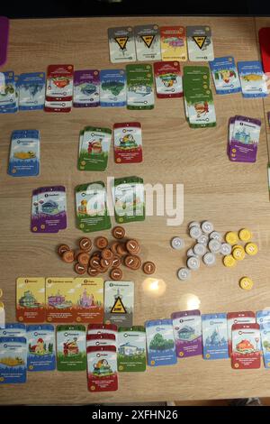 Mozyr, Weißrussland, 10. April 2024: Brettspiel Machi Koro. Gameplay. Sammeln und Verteilen von Münzen. Stockfoto