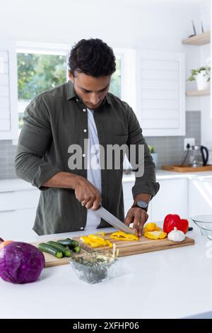 Gelbe Paprika hacken, Mann, der Gemüse in der modernen Küche zubereitet Stockfoto