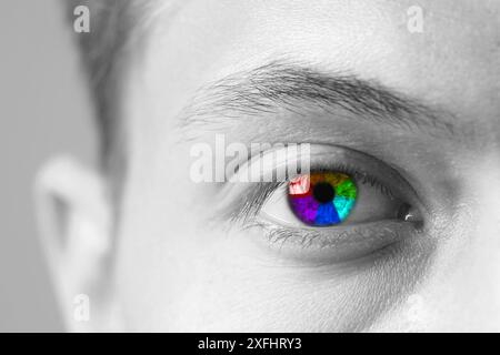 Das Auge des Mannes ist in Regenbogenfarben getönt, Nahaufnahme Stockfoto