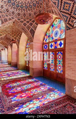 Malerischer Blick auf das Morgensonnenlicht, das durch bunte Buntglasfenster auf dem Boden des Gebetssaals in der Nasir al-Mulk Moschee (Rosa Moschee) reflektiert wird Stockfoto