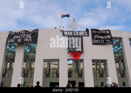 4. Juli 2024, Australien, Canberra, Parlamentsgebäude. Pro-palästinensische Demonstranten klettern auf das Dach des australischen Parlaments, um Banner zu entfalten, die die Rolle der australischen Regierung bei der Förderung des Völkermords in Gaza kritisieren Stockfoto