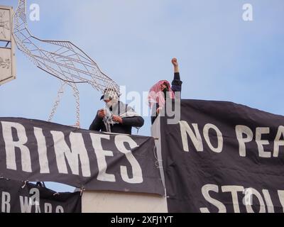 4. Juli 2024, Australien, Canberra, Parlamentsgebäude. Pro-palästinensische Demonstranten klettern auf das Dach des australischen Parlaments, um Banner zu entfalten, die die Rolle der australischen Regierung bei der Förderung des Völkermords in Gaza kritisieren Stockfoto