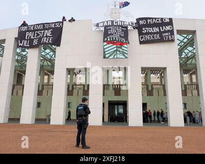 4. Juli 2024, Australien, Canberra, Parlamentsgebäude. Pro-palästinensische Demonstranten klettern auf das Dach des australischen Parlaments, um Banner zu entfalten, die die Rolle der australischen Regierung bei der Förderung des Völkermords in Gaza kritisieren Stockfoto