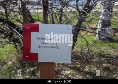 Künstlerschild auf der hölzernen Kuhskulptur auf der Milchfarm La Ferme Gilles Landry am QC 132 in Rivière-Ouelle, Quebec, Kanada Stockfoto