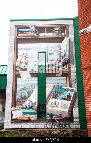 Frau liest ein Buch in einem hölzernen Wandgemälde in der öffentlichen Bibliothek Lauréat-Vallière auf Chem. Du Fleuve in Levis, Quebec, Kanada Stockfoto