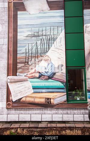 Frau liest ein Buch in einem hölzernen Wandgemälde in der öffentlichen Bibliothek Lauréat-Vallière auf Chem. Du Fleuve in Levis, Quebec, Kanada Stockfoto