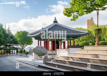 Farbenfroher Glockenpavillon mit traditioneller koreanischer Architektur auf blauem Himmel im Yongdusan Park in Busan, Südkorea. Malerische, sonnige Stadtlandschaft. Stockfoto