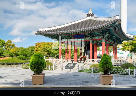 Farbenfroher Glockenpavillon mit traditioneller koreanischer Architektur auf blauem Himmel im Yongdusan Park in Busan, Südkorea. Malerische, sonnige Stadtlandschaft. Stockfoto