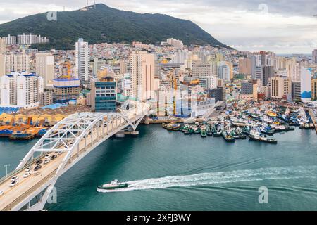 Malerischer Blick auf die Busandaegyo Bridge und den Hafen von Busan in Südkorea. Boot überquert den Hafen. Wunderschönes Stadtbild. Stockfoto