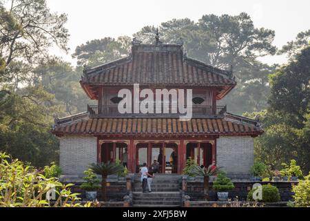 Wunderschöner abendlicher Blick auf den Minh Lau Pavillon (heller Pavillon) zwischen grünen Bäumen am Minh Mang Grab in Hue, Vietnam. Stockfoto
