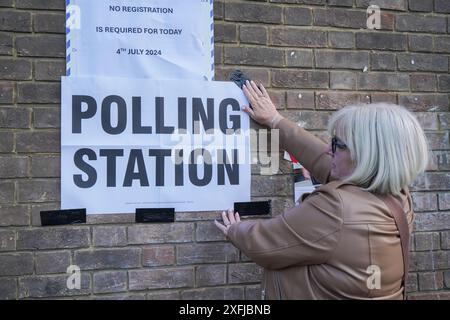 Wimbledon, London, Großbritannien 4. Juli 2024. Ein wahlkommissar platziert in Wimbledon ein Wahllokal-Schild, während sich die Wähler auf die Wahlen bei den britischen Parlamentswahlen vorbereiten. Die letzte Umfrage der britischen Regierung prognostiziert einen Sieg der Labour-Partei, bei dem Sir Keir Starmer als Premierminister prognostiziert wird. Quelle: Amer Ghazzal/Alamy Live News Stockfoto