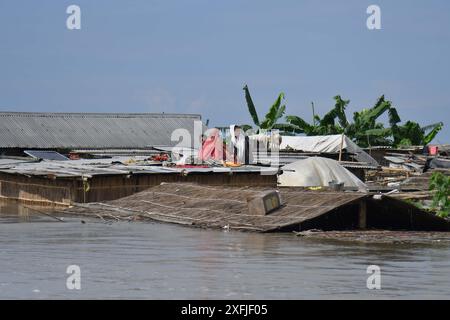 Morigaon. Juli 2024. Die Dorfbewohner nehmen Zuflucht auf der Spitze ihrer teilweise untergetauchten Hütte in einem von Überschwemmungen betroffenen Gebiet im Bezirk Morigaon im nordöstlichen indischen Bundesstaat Assam, 3. Juli 2024. Quelle: Str/Xinhua/Alamy Live News Stockfoto