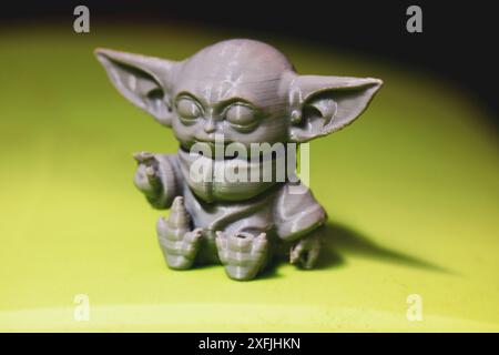 Madrid, Spanien 7. Mai 2024 DIN Grogu, Star Wars Spielzeugheld aus recyceltem Kunststoff isoliert auf grünem Hintergrund. Happy Baby Yoda aus der Disney-Serie. Stockfoto